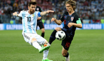 Lionel Messi berduel dengan Luka Modric.